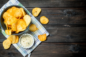 Potato chips with sauce on a napkin.