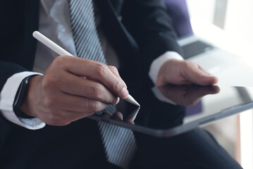 Businessman using stylus pen signing on e-document on digital tablet via mobile app at modern...