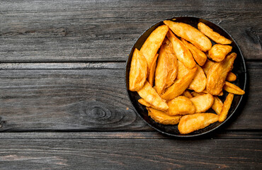 Baked potato slices in a frying pan.