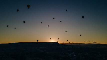 Hot air balloon flying over rock landscape at Cappadocia Turkey