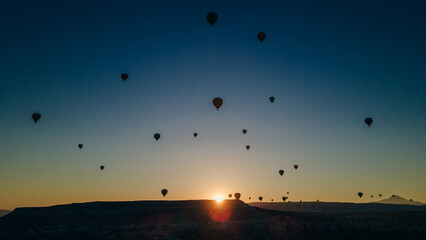 Hot air balloon flying over rock landscape at Cappadocia Turkey