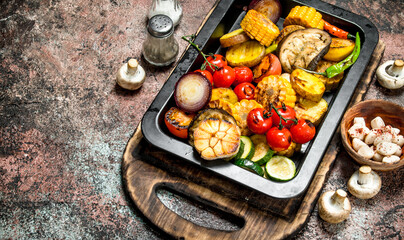Roasted vegetables and mushrooms grilled in a pan.