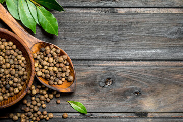Black pepper peas in bowl with spoon and Bay leaves.