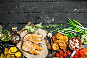 Grilled salmon steaks with grilled vegetables .