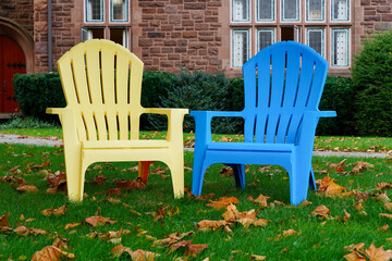 colorful Adirondack lawn chairs blue, yellow autumn leaves
