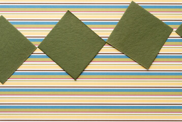 Obraz premium moss green paper tiles or squares on scrapbook paper with stripes