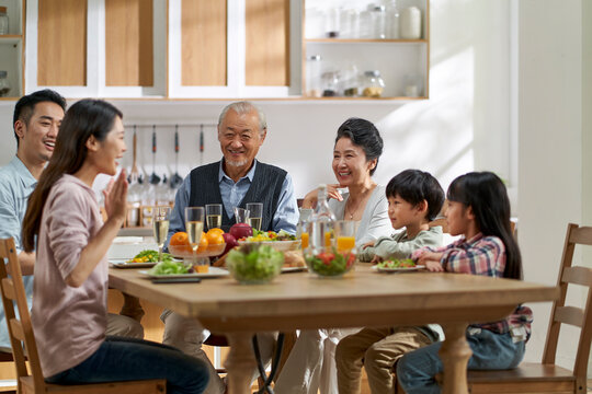 asian family chatting while eating meal