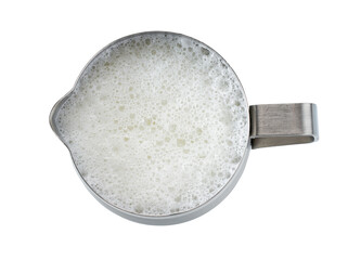 metallic pitcher with whipped milk isolated on white background, top view.