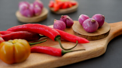 Indonesian chili sauce ingredients isolated on black background. Red chili, shallot, hillbilly tomato, red hot chili pepper.