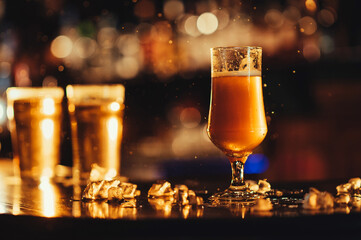 glass of light unfiltered draft beer with on bar counter with drops of spray in restaurant