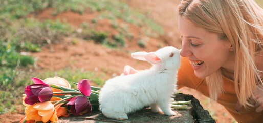 Beautiful young woman with bunny rabbit on farm. Happy easter. Rabbit and funny girl. Easter banner, mockup copy space, header for website, template.