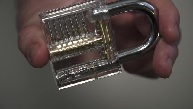 Clear padlock closes in slow motion showing mechanisms inside 
