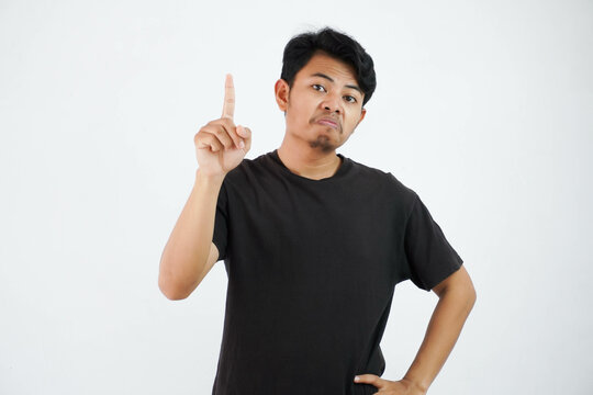 Amazed Or Proud Young Asian Man Wearing Black T Shirt Standing Point Finger Up Isolated On White Background