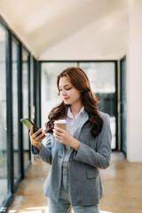  Working woman concept a female manager attending video conference and holding tablet, smatrphone and  cup of coffee in office.