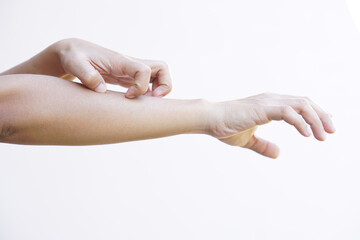 Woman scratching arm from itching on light gray background. Cause of itchy skin include insect...