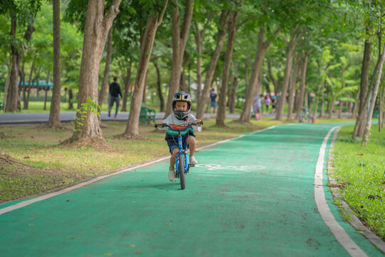 Little asian bpy enjoying ride bicycle in city public park
