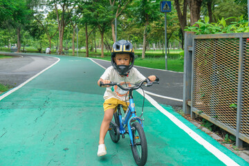 Little asian bpy enjoying ride bicycle in city public park