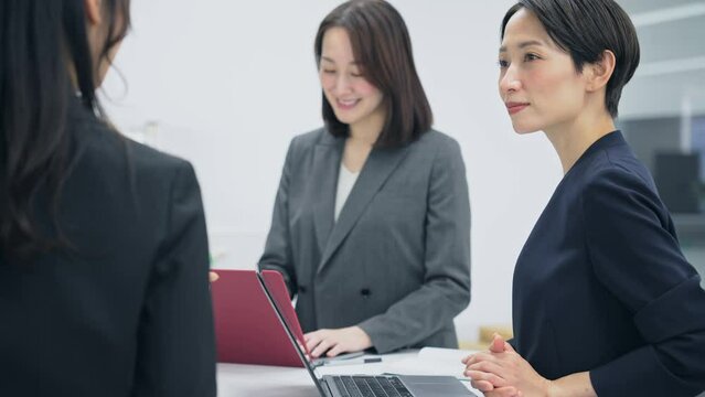 ミーティングする女性会社員グループ