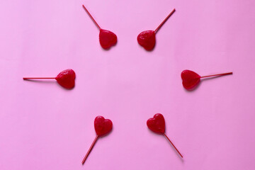 valentine background. heart shaped lollipops arranged in a circle on a pink background leaving free...
