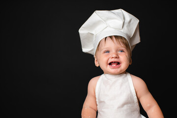 Portrait of laughing little boy in a suit of the cook dirty in flour. Free Space for text.