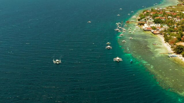 Coral reef and turquoise water with Philippine boats in the famous diving spot of Moalboal, Cebu. Aerial view, Summer and travel vacation concept