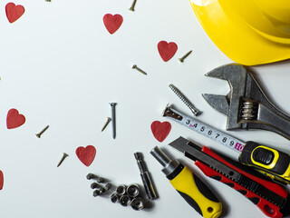Construction tools, hard hat on white background with small red hearts and copy space. Construction...