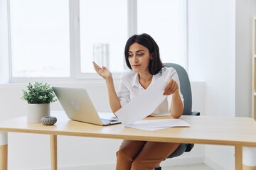 Obraz premium Woman business works at her laptop at home in her office, freelance employee in business, problems with work and paperwork