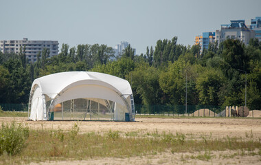 Fototapeta na wymiar White large tents on the sand against the sky.
