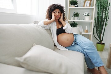 Pregnant woman headache lies at home on the couch fatigue and heaviness in the last month of pregnancy before childbirth, motherhood difficulties