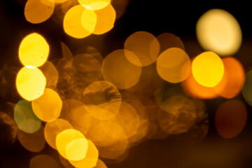 Bokeh abstraction, round bright multi-colored lights out of focus, holiday background.