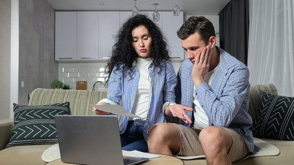 Married couple tries to figure out problems with expensive utility bills and complains about huge prices for communal services. Man and woman tries to pay bills