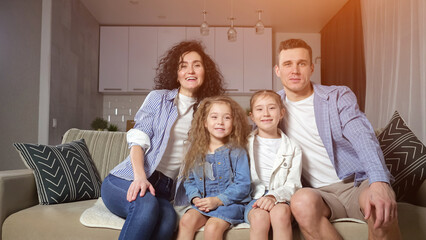 Girls siblings fall on cosy sofa and enjoy playing at home together. Preschooler girl and junior...