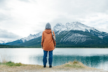 girl standing with her back to the viewer among the mountains banff, canada