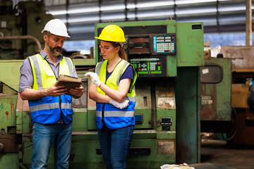 Service and maintenance concept. Service manager male engineer explain the procedure for using the correct metal robot machine at lathe industrial factory.