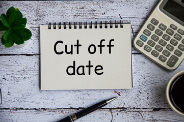 Cut off date text on notepad with table plant, calculator and pen background. Deadline concept.