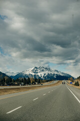 Scenic road through the Canadian Rockies, surrounded with rocky mountains. Taken in Banff National Park, Alberta, Canada