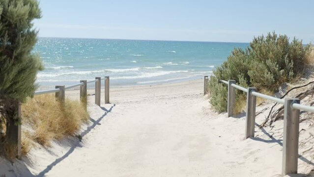 Walking toward beach on sand path with
handrails on sunny day Grange Beach South Australia