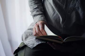 Read book. A man sits and reads literature. Textbooks to study. Religion.