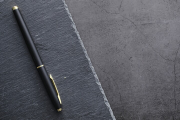 Office supplies on the table. A fountain pen. Business pen in the office on a stone surface.