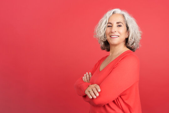 Proud happy mature woman looking at camera with arms crossed