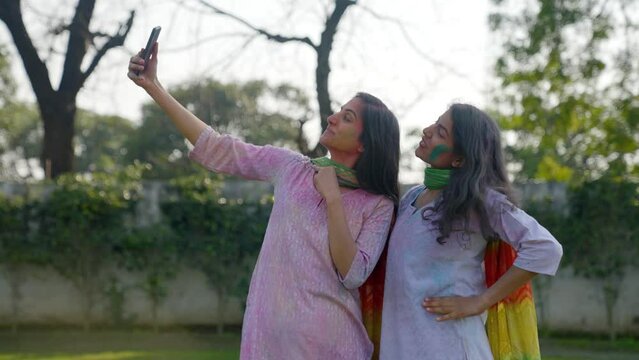 Indian women clicking pictures at a Holi festival