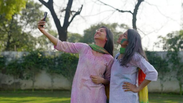 Indian girls clicking pictures at a Holi festival
