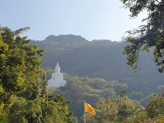 A large white Buddha statue in the middle of a beautiful green valley  Natural atmosphere of Wat Phra Khao, Khao Yai, Thailand