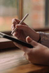 S. setting goals on a tablet while working at a café.