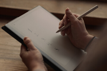 S. setting goals on a tablet while working at a café.