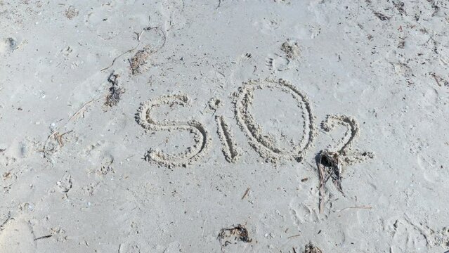 SiO2 Silicon Dioxide Silica written on beach in sand
with finger