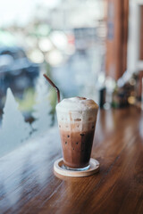 Iced Chocolate drink on indoor table near the glass window
