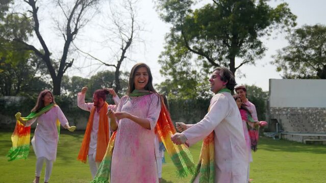 Group of Indian people dancing at a Holi party