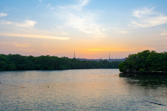 A beautiful sunset with a colorful sky above a river is a sight to behold. The sky is filled with hues of oranges, yellows, pinks, and purples, casting a warm glow over the river.