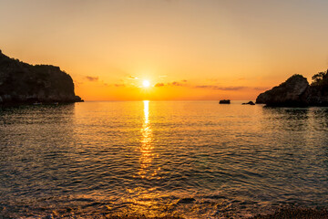 morning or evening landscape with nice beach , a sunrise or sunset in sea with amazing isle with rocks and beautiful clouds on background